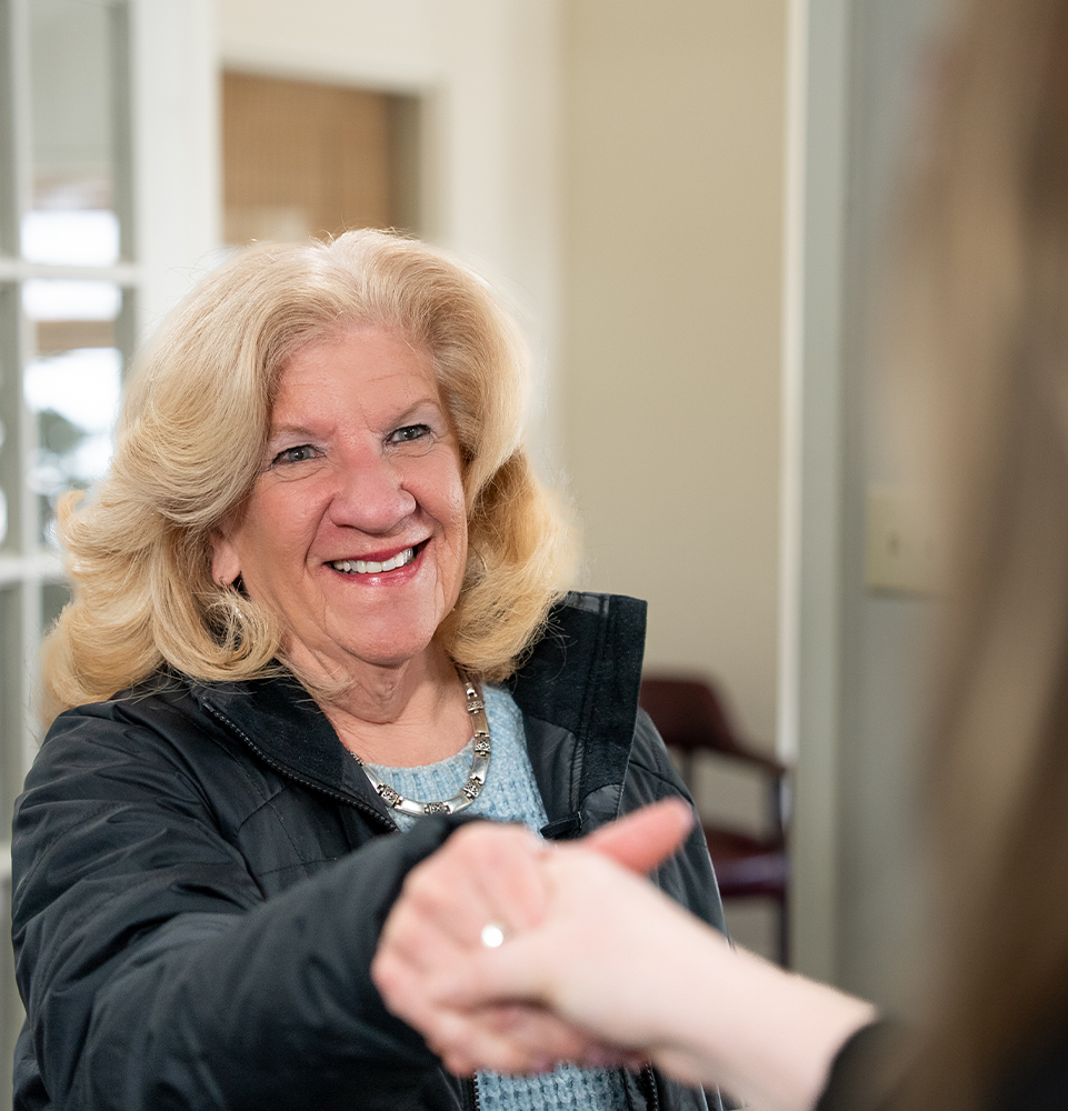 patient shaking hand with staff member when walking into office